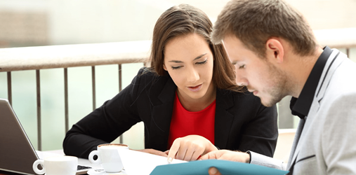 Two people filling out a workers compensation claim.
