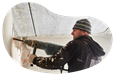 A restoration contractor uses a demolition hammer on a wall.