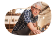 A woodworker smooths the surface of a piece of furniture.