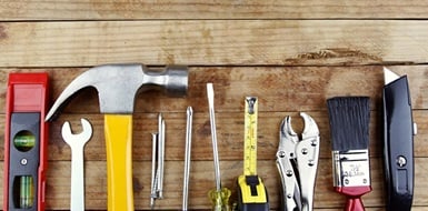 Tools lined up in a row on a contractor's work bench.