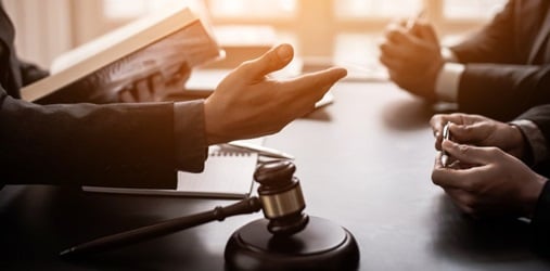 A group of lawyers consulting behind a gavel.