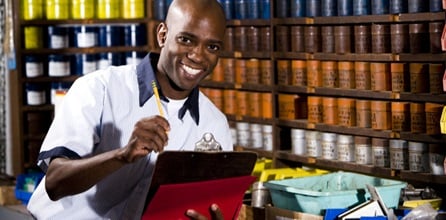 Man with a clipboard doing inventory in a stock room.