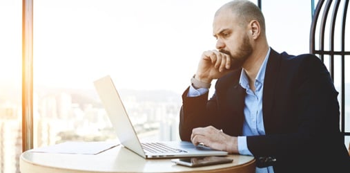 Man looks at his computer with concern.