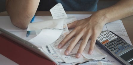 Man becomes overwhelmed calculating receipts.