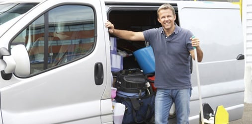 Man stands by a van full of cleaning supplies.