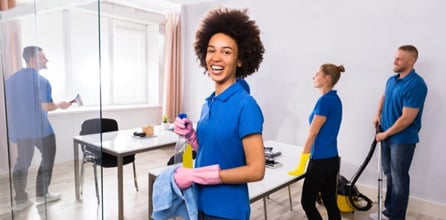 A team of janitors cleans an office space.