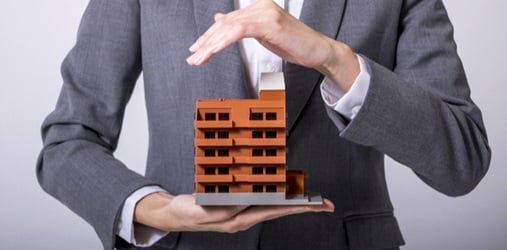A man holding a model of an office building.