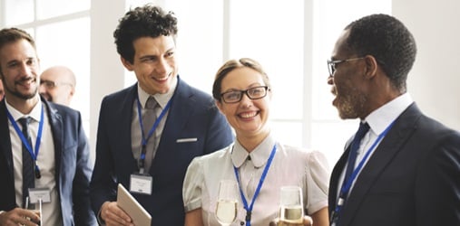 A group of people converse at a work event.