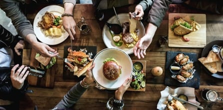 Plates of food on a table in a restaurant from above.