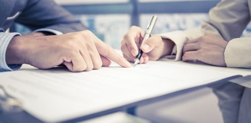 Closeup of hands signing a contract.