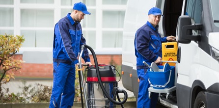 Two janitors with cleaning equipment