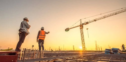 Two construction workers surveying a job site