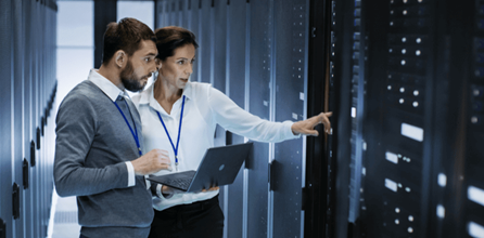 IT consultant conferring with client in server room.