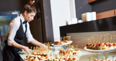 A caterer setting up a table of food at an event