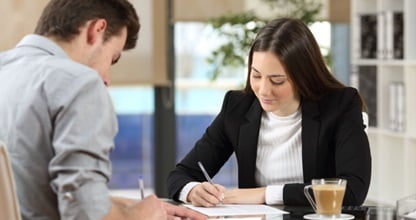 A business owner reviews a document with a client.