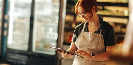 Small business owner comparing insurance companies on tablet