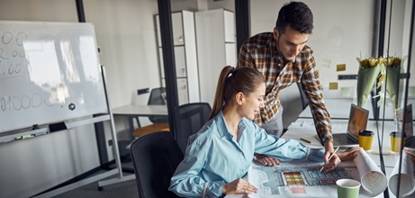 Two small business professionals reviewing paperwork for a specific project