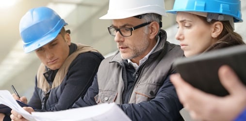 Architects and engineers closely examining a project plan.