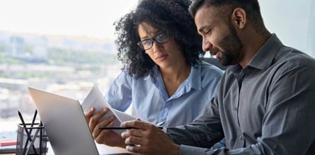 Two coworkers reading a document