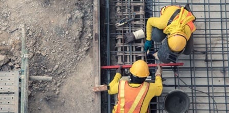 Construction contractors measuring the surface area of a work site.