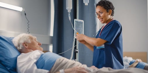 A nurse assisting an elderly patient in a hospital room.