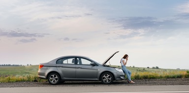 Woman stranded next to a broken car