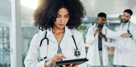 Doctor reviewing patient information on tablet.