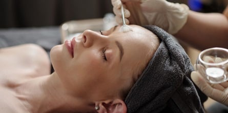 Spa client receiving a facial from a licensed esthetician.