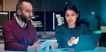 Cybersecurity experts discussing over a computer