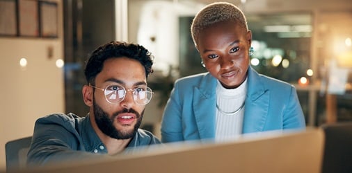Cybersecurity experts discussing over a computer.