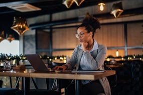 Small business owner working on a laptop in a restaurant.