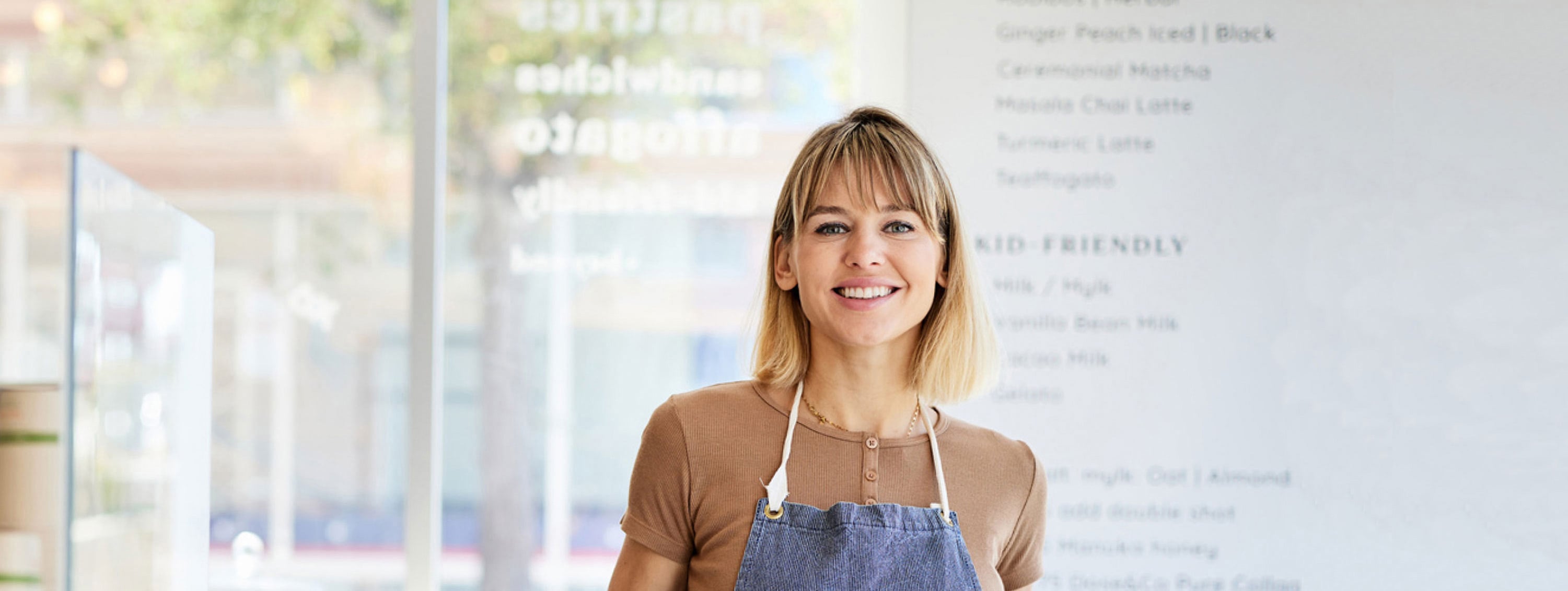 Person in apron standing in store. Person in apron standing in store.