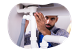 A drain cleaning contractor examines a new plumbing fixture.