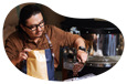 An employee scoops freshly roasted coffee beans into a bag.