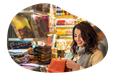 A shopper examines a colorful scarf in a mall kiosk.