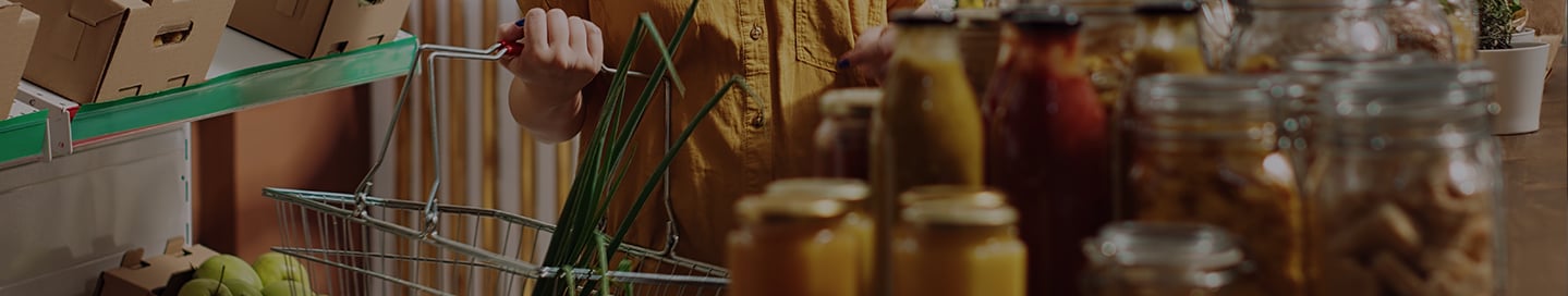 A customer shops with a handbasket in a specialty food store. A customer shops with a handbasket in a specialty food store.