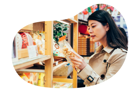 A shopper picks up a bag of popcorn in a specialty food store. A shopper picks up a bag of popcorn in a specialty food store.