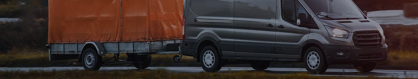 A high roof cargo van pulling a utility trailer. A high roof cargo van pulling a utility trailer.