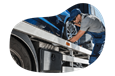 A technician checks the tires on a vehicle loaded onto a car hauler.