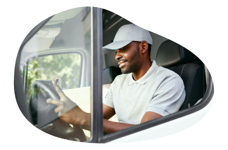 A driver sitting in a vehicle looking at a tablet.
