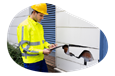 Contractor inspecting environmental damage to business property.