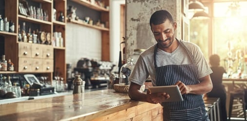 Smiling business owner at a counter.